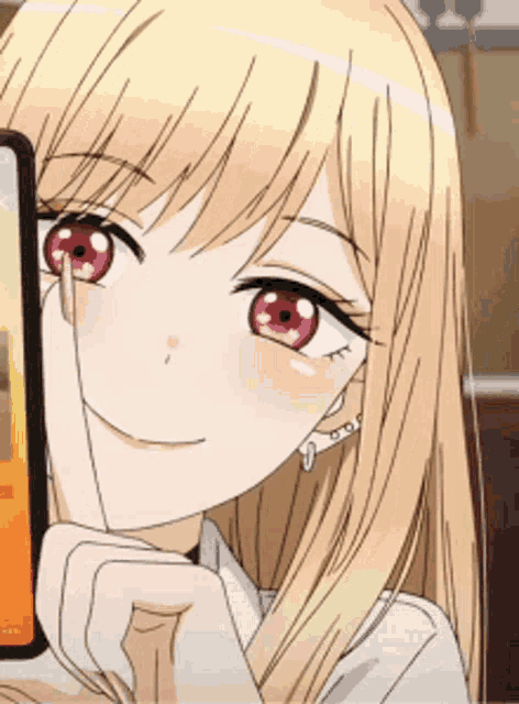 a blonde anime girl with red eyes is holding a cell phone to her face