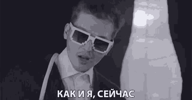 a black and white photo of a man wearing 3d glasses and a white shirt .