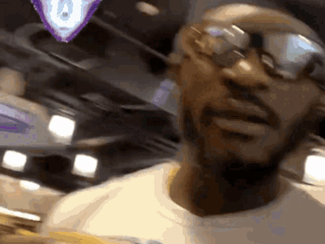 a man wearing sunglasses and a white shirt looks at the camera .