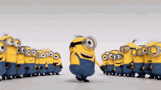 a group of minions are standing in a line and one of them is wearing goggles