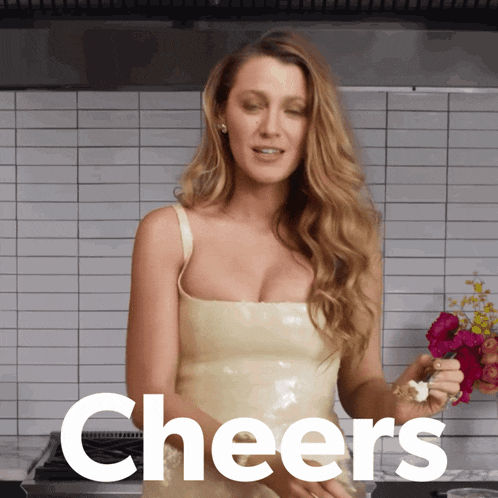 a woman in a white dress is holding flowers and cheers