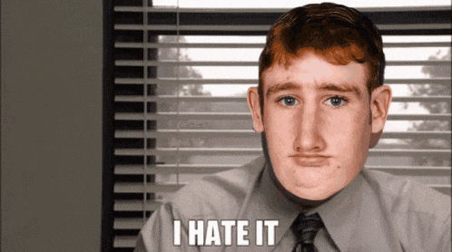 a man in a suit and tie says i hate it in front of a window