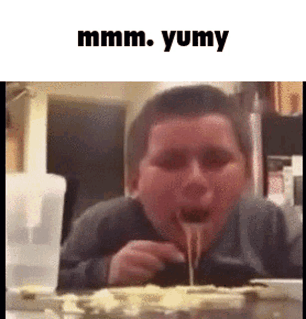 a young boy is eating spaghetti with a fork and the words mmmm yumy are above him