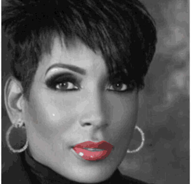 a woman with short hair and red lipstick is wearing hoop earrings and a black turtleneck .