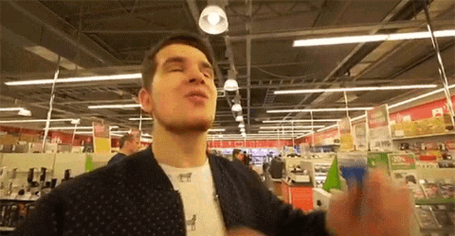 a man in a polka dot jacket is standing in a store and making a face