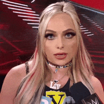 a woman with blonde hair and blue eyes is wearing a choker and a necklace with the letter v on it