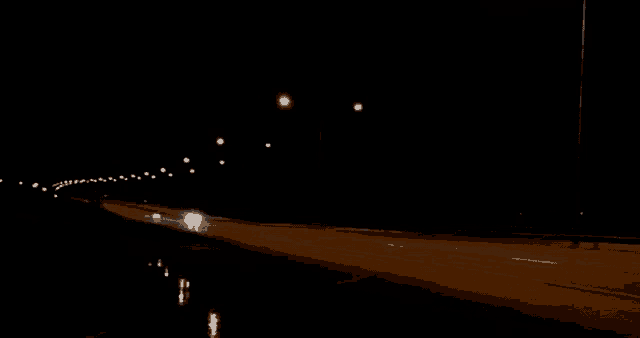 a dark background with a few lights visible