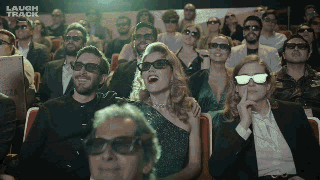 a group of people wearing 3d glasses are watching a movie with laugh track written on the bottom right