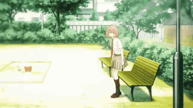 a girl in a skirt and tie is standing next to a bench in a park .