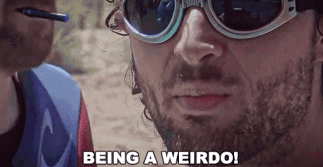 a man wearing sunglasses says " being a weirdo "