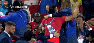 a group of soccer players are hugging each other in a stadium .