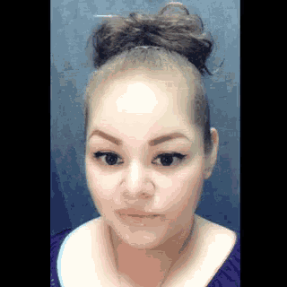 a woman with a bun on her head is wearing a purple top