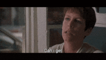 a woman sitting in front of a window says can i get
