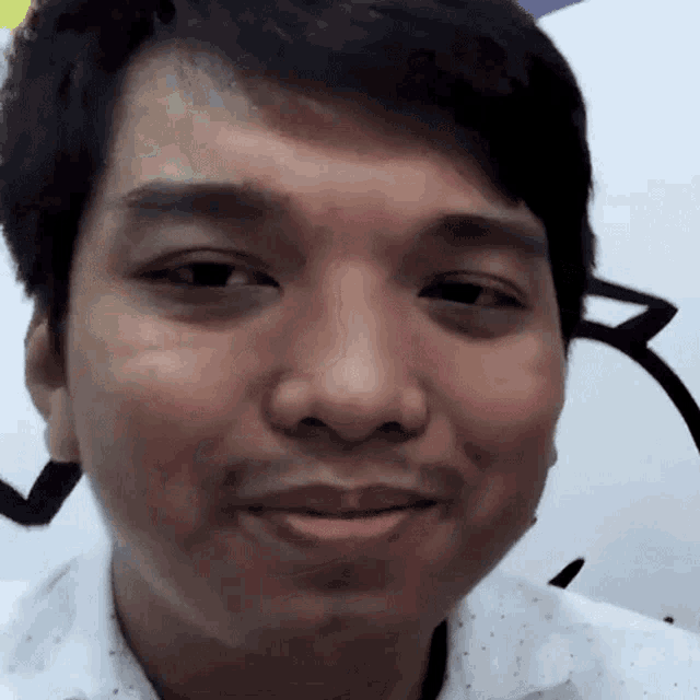 a close up of a man 's face with the letter r visible in the background