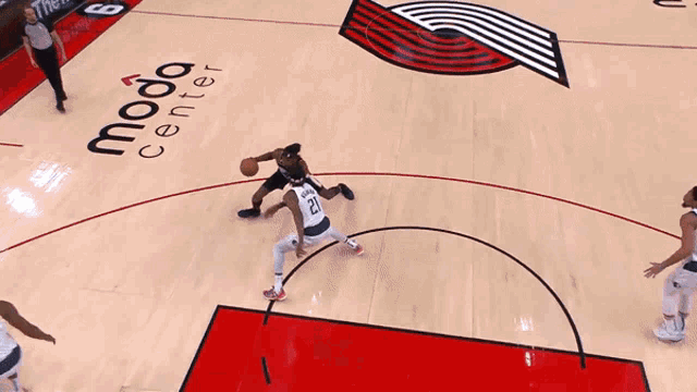 a basketball player wearing a portland jersey goes up for a shot