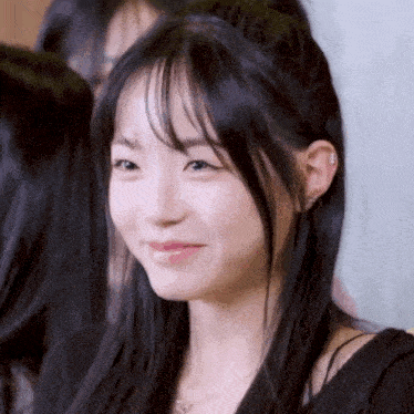 a close up of a girl with long hair and bangs