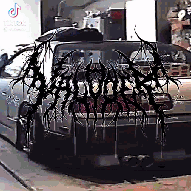 a car is parked in a garage with a black and white logo on the back of the car .