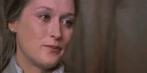 a close up of a woman 's face with tears coming down her face .