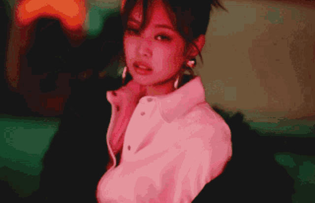 a close up of a woman wearing a white shirt and earrings .