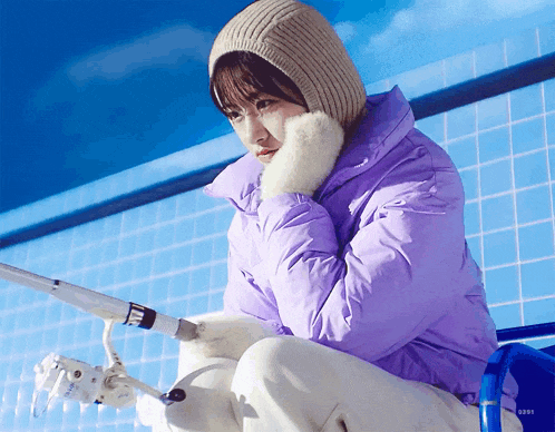 a woman in a purple jacket is holding a fishing rod in front of a pool