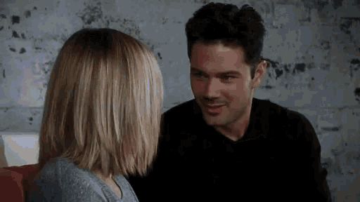 a man and a woman are looking at each other .