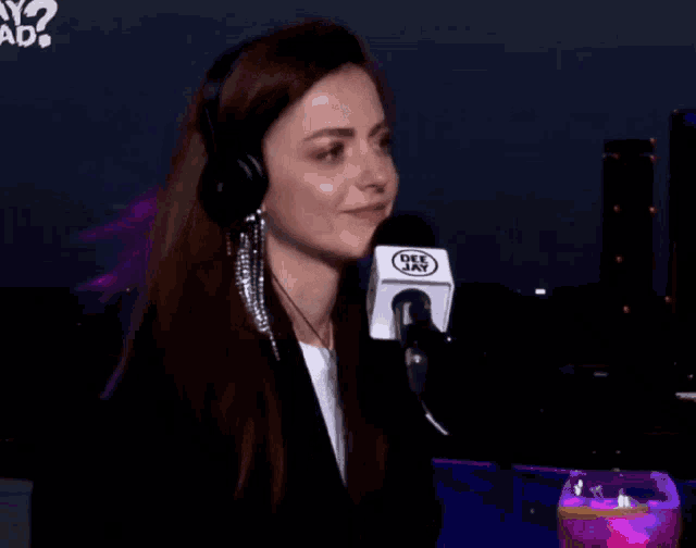 a woman wearing headphones and a microphone that says deejay