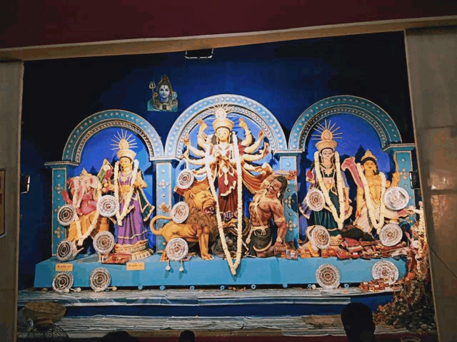 a statue of shiva is above a statue of a woman