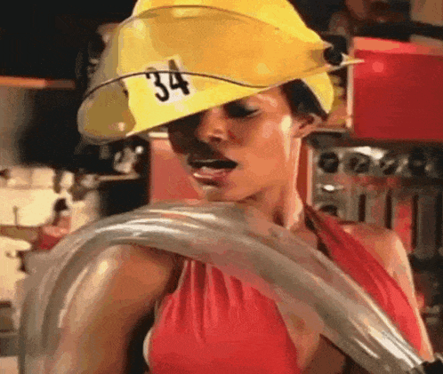 a woman wearing a yellow hard hat with 34 on it