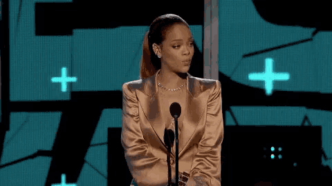 a woman in a gold jacket is speaking into a microphone .