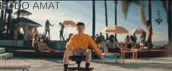 a man in a yellow shirt sits in a chair in front of a pool with the word bodo amat on the bottom