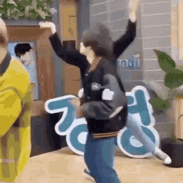 a group of people are dancing in a room in front of a sign .