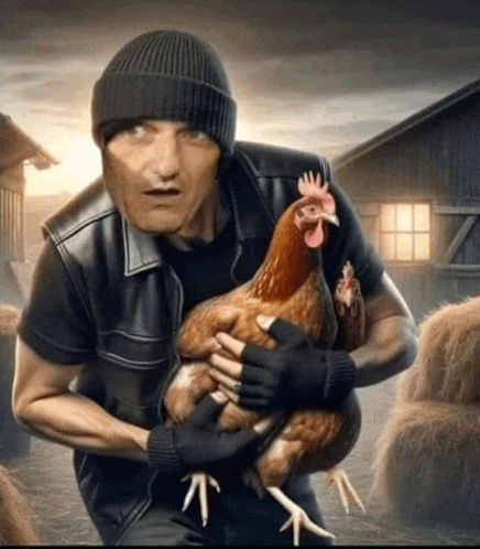 a man in a hat is holding a chicken in his arms .