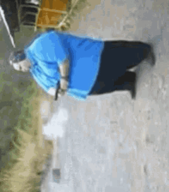 a man in a blue shirt is walking down a street