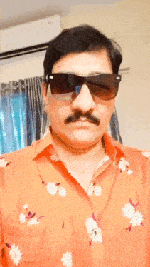 a man wearing sunglasses and a floral shirt