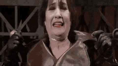 a woman is crying while holding a pair of scissors in her hand .