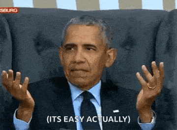 a man in a suit and tie is sitting in a chair and making a funny face .