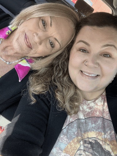 two women are posing for a picture in a car