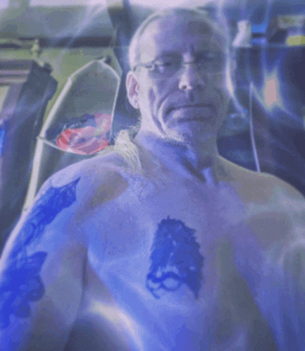 a man without a shirt has a tattoo on his chest