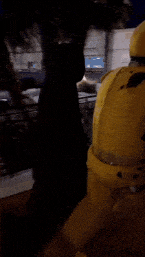 a man in a yellow suit is walking down a bridge at night
