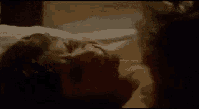 a woman is laying on a bed with her head on another woman 's chest .