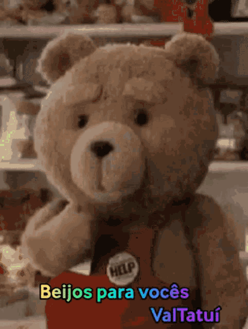 a teddy bear is wearing a red apron with a help button on it