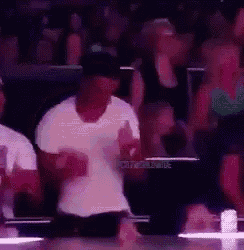 a man is dancing in front of a crowd in a stadium .