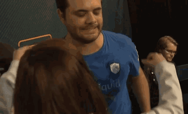 a man wearing a blue shirt with the word quid on it