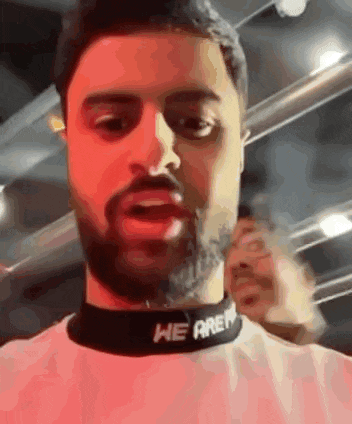 a man with a beard is wearing a choker that says `` we are n '' .