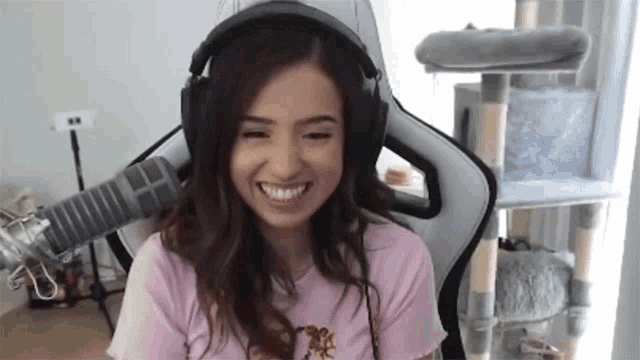 a woman is wearing headphones and smiling while sitting in a chair .