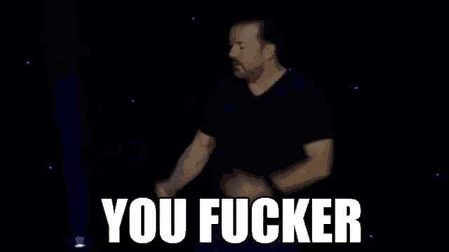 a man is dancing on a stage with the words `` you fucker '' written on it .