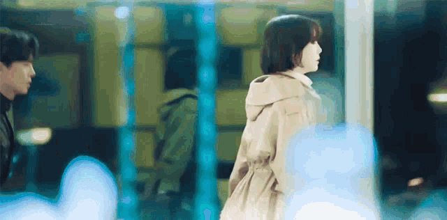 a man and a woman are standing next to each other in front of a glass door .