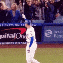 a baseball player in front of a sign that says capital one