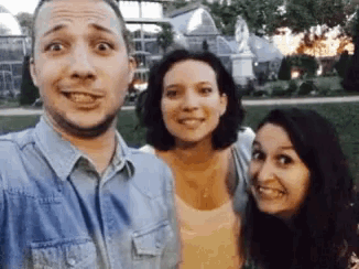 a man and two women are posing for a selfie
