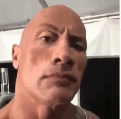 a close up of a bald man 's face with a serious expression .